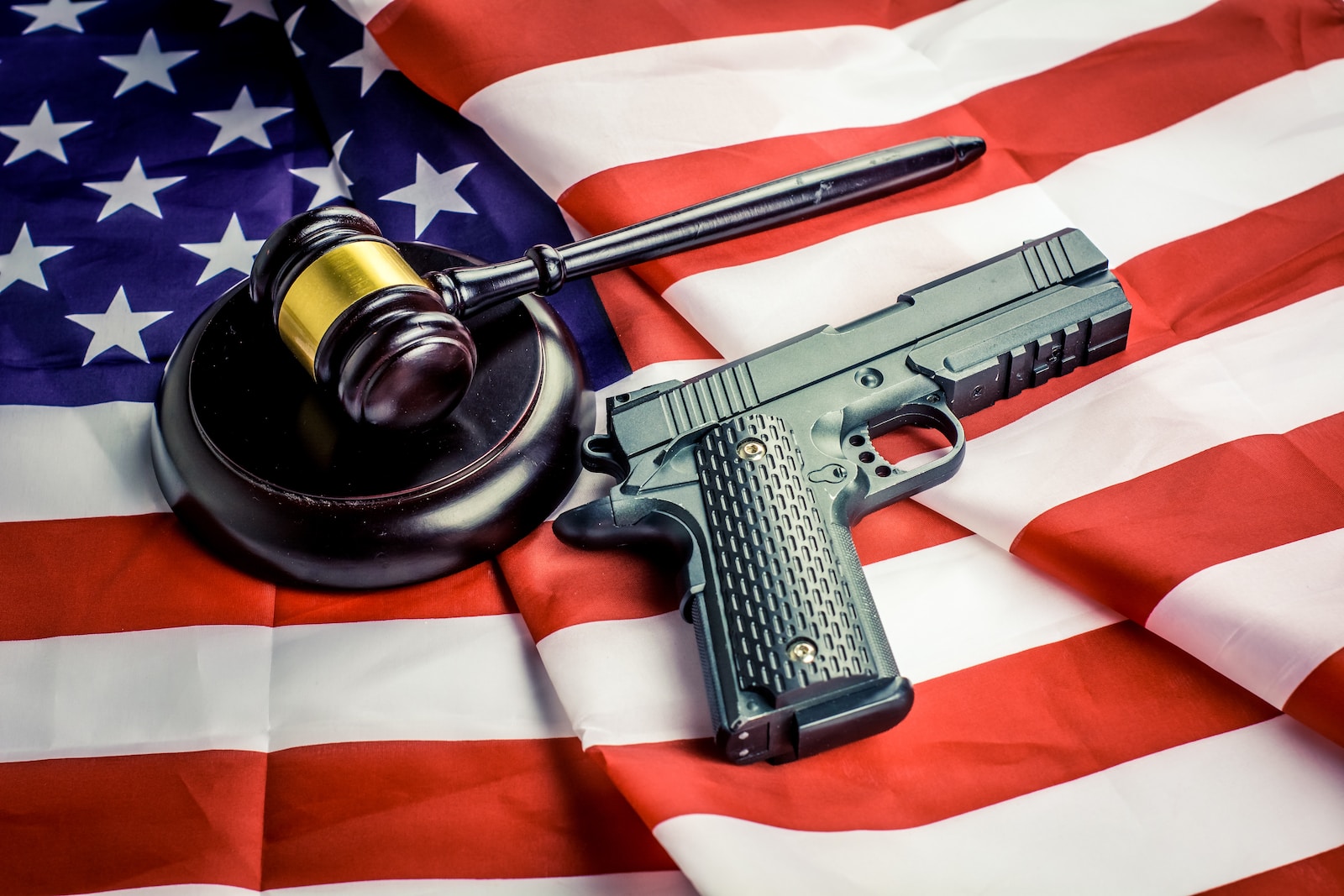 a gun, a judge's hammer, and an american flag